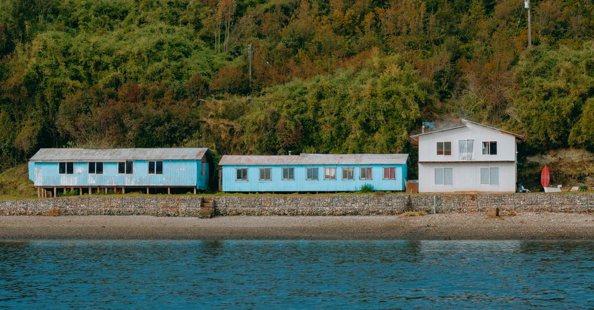 Casas de madera pintadas junto a un puerto tranquilo al atardecer